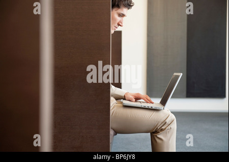 Imprenditore lavora su un computer portatile in un ufficio Foto Stock