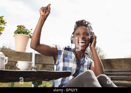 Una donna di ascolto di cuffie, cantare e ballare Foto Stock