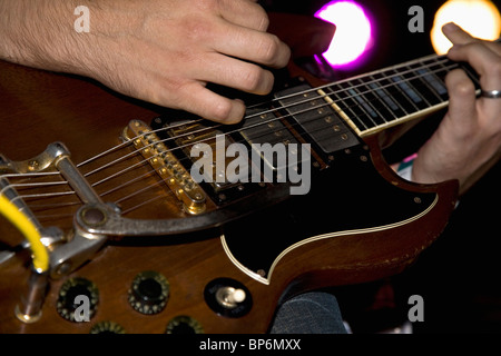 Un uomo suonando una chitarra elettrica, close up delle mani Foto Stock