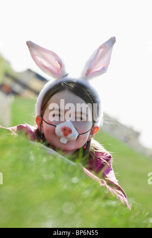 Una ragazza indossando orecchie di coniglio e una maschera Foto Stock