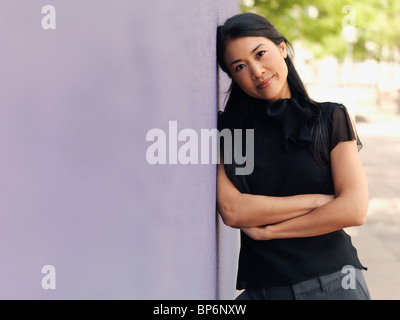 Ritratto di una imprenditrice appoggiato contro una parete Foto Stock