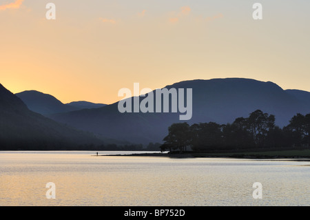 Un fotografo imposta fino a catturare il tramonto su Buttermere nel distretto del lago con Mellbreak oltre Foto Stock