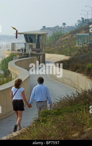 Giovane camminando lungo il seawall at Carlsbad State Beach, Carlsbad, San Diego, California Foto Stock