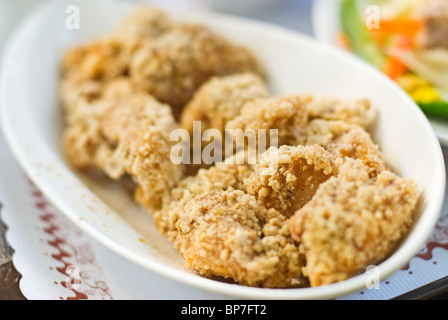 Delizioso fritto di pollo in bianco piatto sul tavolo. Foto Stock