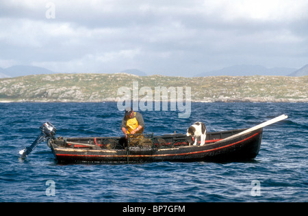 Un pescatore di controllo un lobster pot da un legname currach a Errelough Connemara nella Contea di Galway Repubblica di Irlanda Foto Stock
