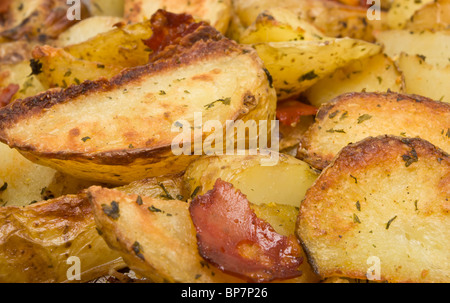 Piccante Spicchi di patate con il salame chorizo sul vassoio da forno direttamente dal forno. Foto Stock