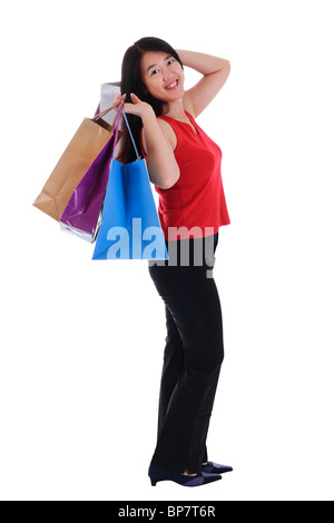 Una donna asiatica in possesso di più shopping bags isolato in uno sfondo bianco Foto Stock