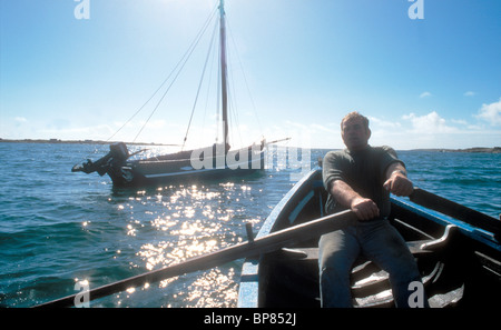 Il canottaggio un legname costruito curragh o currach e a Galway Hooker peschereccio a Errelough nella Contea di Galway Irlanda Foto Stock