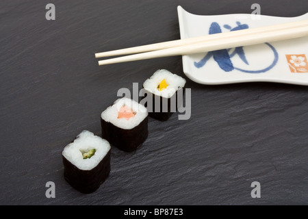 Il Sushi e bacchette sul grigio scuro dello sfondo in ardesia. Foto Stock