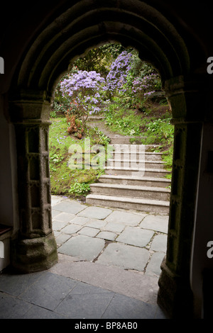 Passi per il giardino. Una serie di passaggi, incorniciato dal portale di ingresso della chiesa derivazioni staccate e in un percorso di giardino Foto Stock