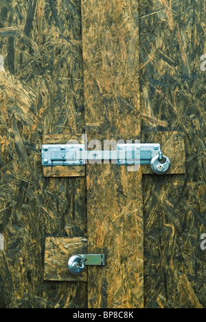 Porta di legno fissato con due lucchetti Foto Stock