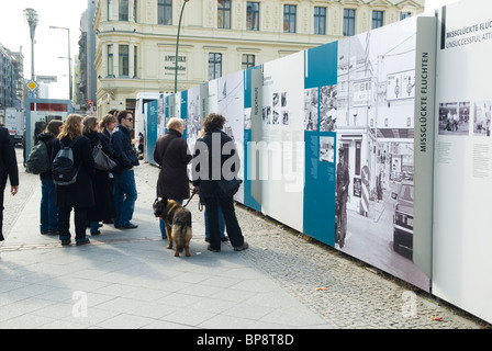 Tourist guardando un outdoor photo gallery al Checkpoint Charlie Berlino Germania Foto Stock