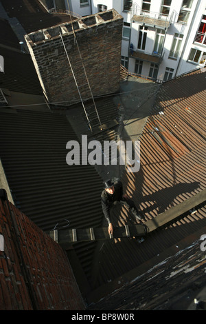 Spazzacamino sul ferro corrugato tetto, Berlino, Germania Foto Stock