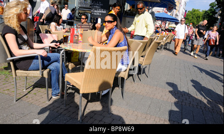 Colonia / Köln, Renania settentrionale-Vestfalia (Germania). Persone presso il cafe le tabelle in strada Foto Stock