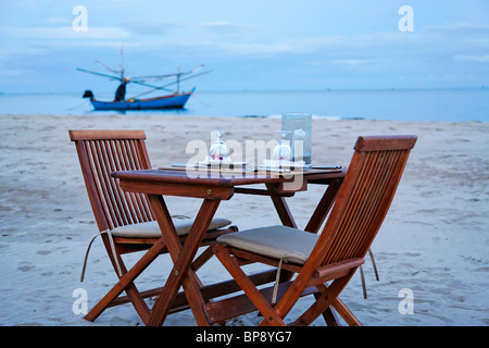 Un tavolo e sedie fuori sulla spiaggia, Thailandia Foto Stock