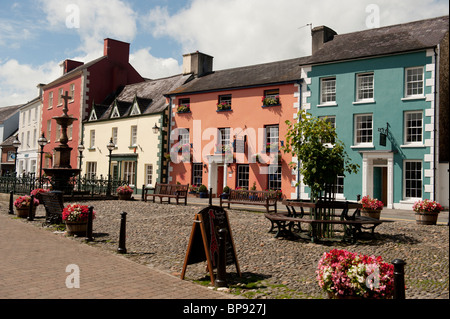 Una fila di pastello dipinto di epoca georgiana periodo case di città intorno a ciottoli piazza mercato Llandovery, Carmarthenshire Wales UK Foto Stock