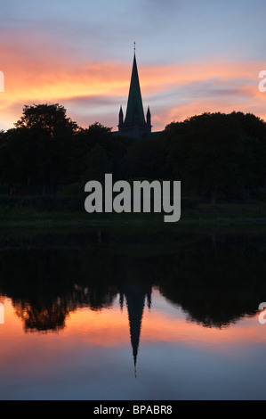 Silhouette tramonto riflesso della cattedrale di Nidaros nel fiume Nidelva, Trondheim, Norvegia Foto Stock