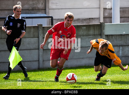 Una città di Warrington winger corre con la palla oltre a caduta di Ossett Albion defender a Dimplewells Road, Ossett Foto Stock