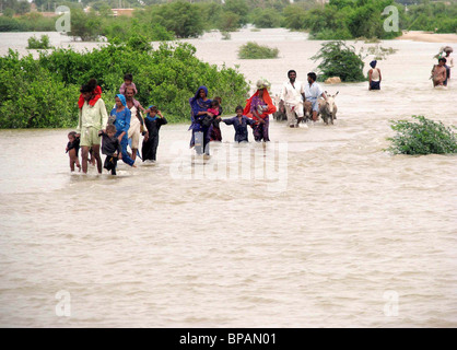 Colpite dalle alluvioni la gente si sposta verso il luogo sicuro attraverso la zona allagata dopo che le loro case erano state annegate in alluvioni ad unar pur in Foto Stock