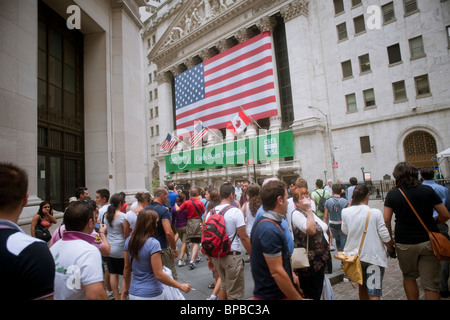 Orde di turisti vagare l'intersezione di ampia e strade di parete presso il New York Stock Exchange di New York Foto Stock