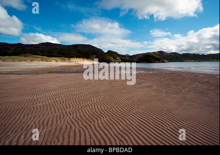 Distante giovane e cane sulla spiaggia di Baia Gruinard Wester Ross Highlands scozzesi Scotland Regno Unito Foto Stock