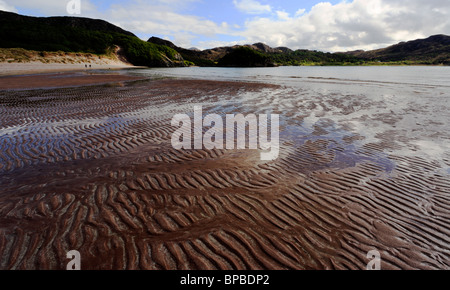 Distante giovane e cane sulla spiaggia di Baia Gruinard Wester Ross Highlands scozzesi Scotland Regno Unito Foto Stock