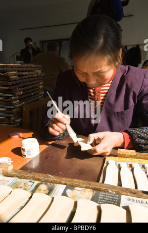 Pettine di pittura per lavoratrice di fabbrica femminile presso la fabbrica cinese di pettini, Changzhou. Cina. Foto Stock