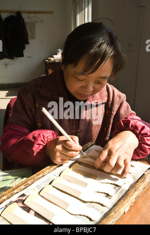 Pettine di pittura per lavoratrice di fabbrica femminile presso la fabbrica cinese di pettini, Changzhou. Cina. Foto Stock