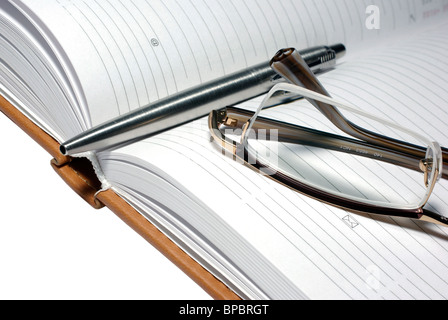 Penna in acciaio, bicchieri e agenda. Foto Stock
