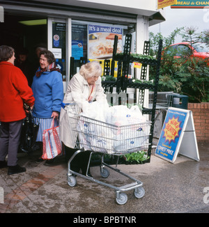 Una donna anziana con un intero carrello al di fuori della Co op supermercato Brecon Galles Wales UK KATHY DEWITT Foto Stock
