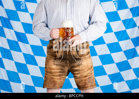 Uomo bavarese con birra Oktoberfest stein (massa) e pantaloni in pelle (Lederhose) Foto Stock