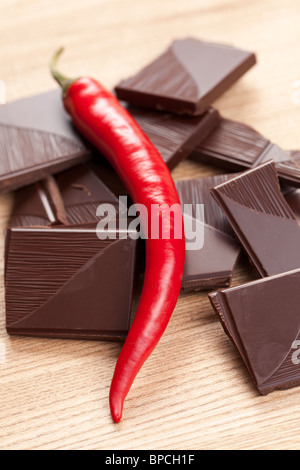 Il peperoncino scuro cioccolato sulla tavola di legno Foto Stock