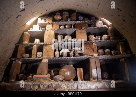 Scaricate vasi di ceramica e altri oggetti impilati in un forno anagama dopo la cottura Foto Stock