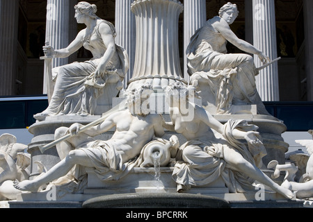 Una dettagliata fontana in marmo bianco con più figure scolpite in stile classico. Due figure femminili sedute sono posizionate su entrambi i lati di una colonna scanalata centrale, ciascuna contenente un bastone o. Foto Stock