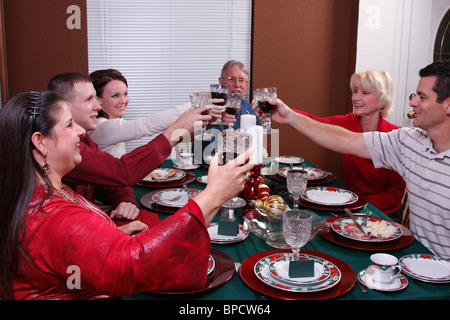 Famiglia la tostatura in cena di Natale Foto Stock