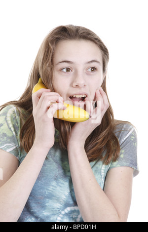 Teen ragazza con una banana come un telefono Foto Stock