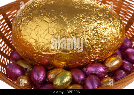 Grandi e piccole di lamina di oro avvolto uova di pasqua di cioccolato in un cestello Foto Stock