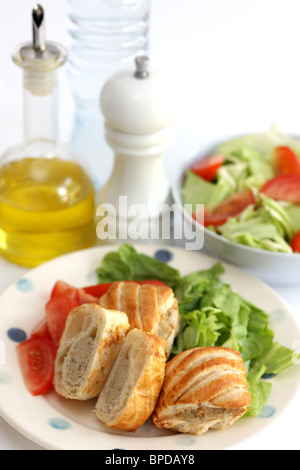 Appena sfornato salsiccia salati dei rotoli di pasta con una mista fresca insalata di giardino contro uno sfondo bianco e nessun popolo Foto Stock