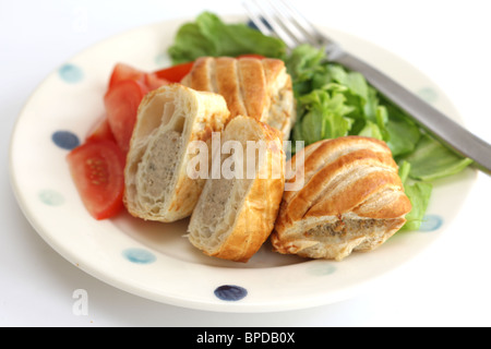 Appena sfornato salsiccia salati dei rotoli di pasta con una mista fresca insalata di giardino contro uno sfondo bianco e nessun popolo Foto Stock