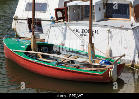 Barca a vela tradizionale dinghy ormeggiato a case galleggianti sul fiume Tamigi o Isis tra Oxford e Wolvercote, Oxfordshire, Regno Unito Foto Stock