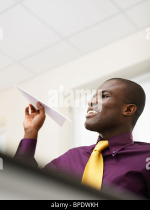 Imprenditore nero gettando aeroplano di carta Foto Stock