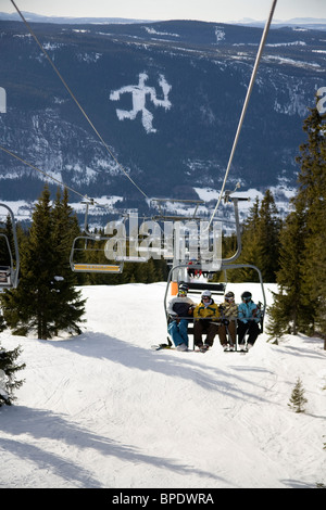 Gli sciatori su un ponte elevatore a Hafjell, Norvegia con il Lillehammer simbolo olimpico in background. Foto Stock