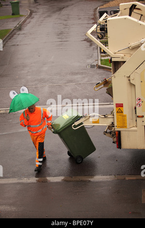 Agosto 2010 - riciclaggio dei rifiuti camion e equipaggio in azione in una giornata bagnata sotto la pioggia Foto Stock