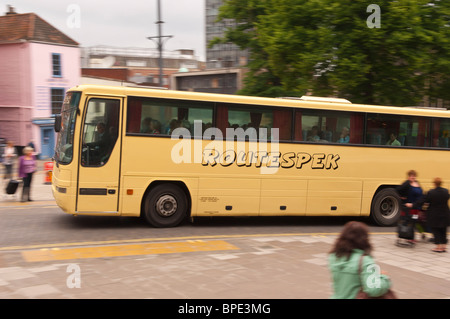 Un giallo Routespek coach guida attraverso la città che mostra il movimento in Norwich , Norfolk , in Inghilterra , Gran Bretagna , Regno Unito Foto Stock