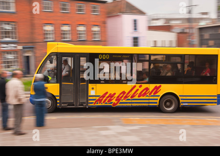 Un giallo Anglian bus granturismo guida attraverso la città che mostra il movimento in Norwich , Norfolk , in Inghilterra , Gran Bretagna , Regno Unito Foto Stock