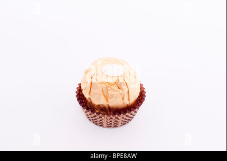 Una chiusura spaccato di un Ferrero Rocher cioccolato su sfondo bianco Foto Stock