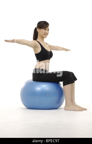 Giovane donna a praticare yoga sulla palla ginnica Foto Stock