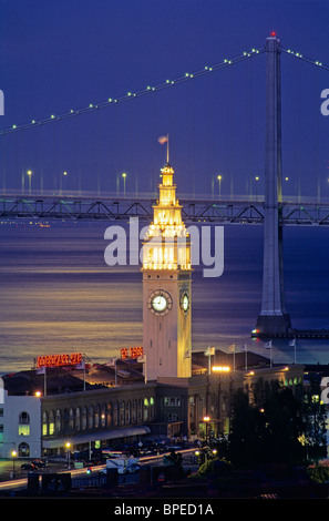 Stati Uniti, California, San Francisco, Ferry Building, Oakland-San Francisco Bay Bridge, luna riflessa su San Franciso Bay, crepuscolo Foto Stock