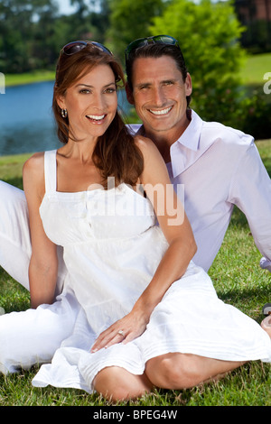 Ritratto di un attraente, di successo e Felice medio di età compresa tra un uomo e una donna giovane di trentenni seduti insieme all'esterno Foto Stock