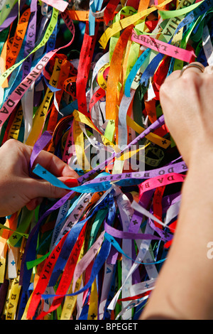 Donna di legatura nastro fortunato a Igreja NS do Bonfim chiesa, Salvador, Bahia, Brasile. Foto Stock